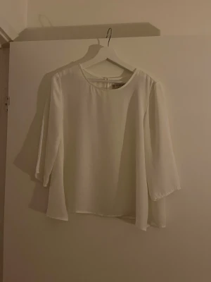 Vit blus från Pull&Bear - Står st M men sitter som en st S!                         Stilren vit blus från Pull&Bear med rund halsringning och lätt transparent material. Blusen har trekvartsärmar och ett luftigt, rakt fall som ger en avslappnad men chic look. Perfekt att matcha med jeans eller kjol för en trendig outfit.  Köpt secondhand 💞