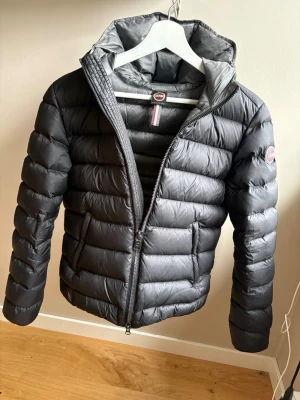 Svart dunjacka från Colmar med huva - Säljer min dunjacka från Colmar perfekt nu till våren som kommer men även till hösten o vintern, den är storlek 44 jag vet tyvärr inte va det är för storlek i tex M  den är använd ett år sen har jag inte använt den då jag tycker att den är lite liten, jag tycke verkligen om den säljer bara den på grund av storleken  tyvärr, OBS jag postar INTE då den är dyr, det är äkta jag är en ärlig person kolla gärna in min andra annons så ser du att jag är ärlig 