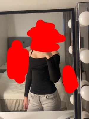 Svart offshoulder topp - Säljer en svart offshoulder topp med lång ärm. Toppen är tight och har en croppad passform som framhäver axlarna. Perfekt att styla med jeans eller kjol för en trendig look.