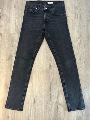Svarta slim fit jeans från Tiger of Sweden - Snygga svarta slim fit jeans från Tiger of Sweden med klassisk femficksmodell och diskreta slitningar. Jeansen har raka ben och normalhög midja. Tillverkade i mjukt denimtyg som ger en skön passform och stilren look.
