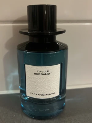 Zara Caviar Bergamot parfym - Zara Caviar Bergamot parfym i en stilren blå glasflaska med svart cylinderformad kork. Flaskan har en modern design och etiketten är vit med svart text. Doften är en del av Zara Ocean/No3-serien och ger en fräsch känsla med inslag av bergamott.