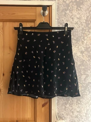 Svart blommig kortkjol - svart blommig kortkjol från H&M. Mycket bra skick aldrig använd. Hör av vid frågor!💗