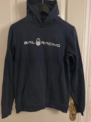 Sail Racing Hoodie - Äkta Sail Racing hoodie i mörkblått, bra i skick! Storlek 170