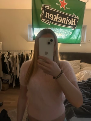 Ljusrosa fluffig kortärmad topp - Supersöt ljusrosa topp med fluffig textur och korta ärmar. Toppen är croppad och har en mjuk, mysig känsla som passar perfekt till jeans eller kjol. Enkel och trendig design utan synliga detaljer eller mönster.