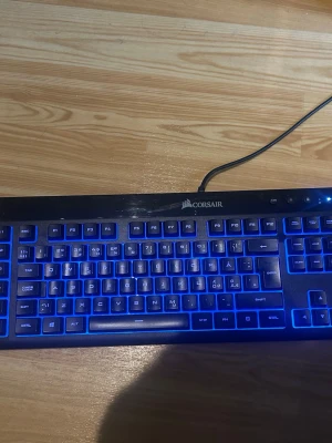 Corsair K55 RGB  - Säljer ett Corsair tangentbord med RGB-belysning som kan växla mellan olika färger som blått och grönt. Tangentbordet har fullstora tangenter, numerisk del och ansluts med USB-kabel. Perfekt för gaming eller datorarbete. Svart plastchassi med snygg bakgrundsbelysning.