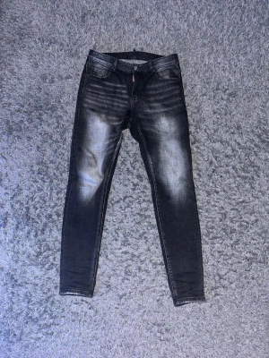 Gråa/svarta dsquared2 jeans - Gråa/svarta dsquared2 jeans med slina effeker på benen. De är som nya bara använda ett fåtal gånger. 