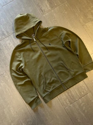 Ralph lauren zipper  - Snygg Ralph lauren zipper frön den nya kollektionen i färgen khaki. Storlek M. Tveka inte att höra av dig med frågor och funderingar och kolla även gärna in mina andra annonser så kan vi säkert fixa ett bra paketpris🤩🤩