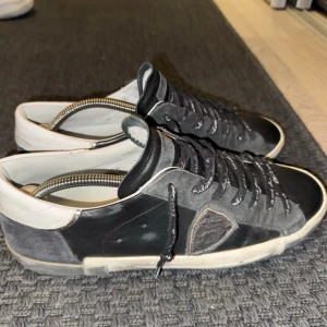 Philippe Model - Svarta låga Philippe model skor i läder med mocka detaljer. De är i ganska fint skick. Storlek 43. Box och kvitto finns. Fråga gärna frågor!