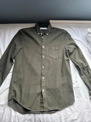 Olivgrön Overshirt  från Samsøe  - Stilren olivgrön Overshirt från Samsøe med klassisk krage, bröstficka och vita knappar. Perfekt till jeans eller chinos för en clean look. Nypris 1200kr, Aldirg andvänd därav inga defekter. Skriv om ni undrar något!✌🏼
