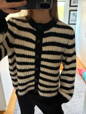 Randig stickad kofta  - Mysig stickad kofta med svart-vita ränder och knappar 
