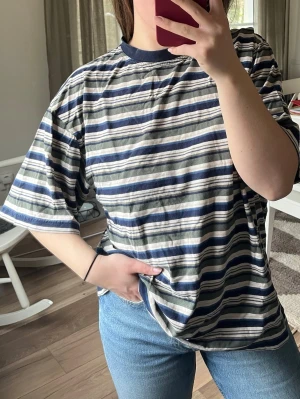 Randig t-shirt - Oversized t-shirt storlek med blå, grå och vita ränder.