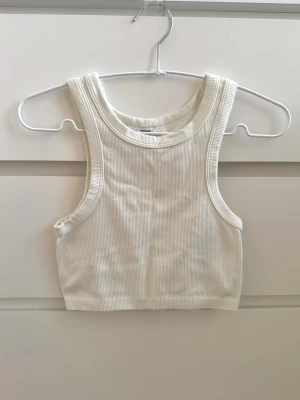 Vit ribbad croppad linnetopp H&M - Säljer en enkel och stilren vit croppad linnetopp i ribbad bomull från H&M. Den är stretchig o skön 💗