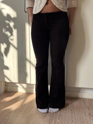 Bruna utsvängda manchesterbyxor - Snygga bruna manchesterbyxor med utsvängda ben och hög midja. Byxorna har klassiska fickor både fram och bak och är gjorda i mjuk, ribbad manchester. Perfekta för dig som gillar retrostil och vill ha ett par bekväma men trendiga byxor.