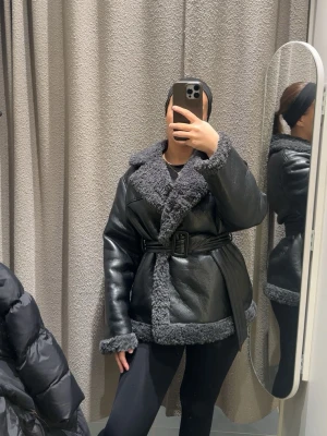 Svart skinnkappa med bälte - Skinnkappa från ginatricot. 