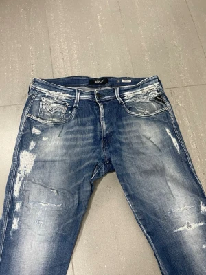 Replay Anbass Jeans - Säljer nu dessa Replay Anbass Jeans med snygga slitningar i populär design, W33 o L30, överlag bra skick förutom liten lagning i skrevet, skriv för fler bilder/frågor🙌🏼