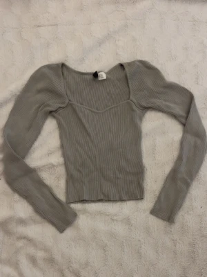  ribbad topp - snygg grå/grön ribbad topp från Divided med lång ärm och fyrkantig urringning. toppen är croppad och har en tight passform som framhäver figuren. 