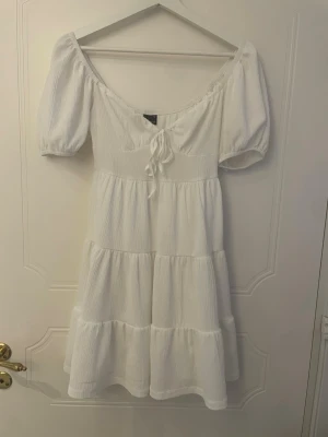 Vit klänning - Gullig vit klänning från Gina Tricot som passar perfekt för skolavslutning eller student!  Storlek XS lite slitningar på baksidan men inte något som märks av vid användning (se sista bilden)   obs! katt finns i hemmet