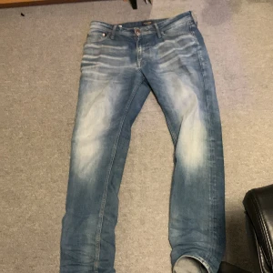 Blå jeans med slitningar - Snygga blå jeans med ljusa slitningar och tvättade detaljer framtill. Klassisk femficksmodell med raka ben och normal midja. Jeansen har en läderpatch bak i midjan och är tillverkade i denim. Perfekta för en avslappnad och trendig look.
