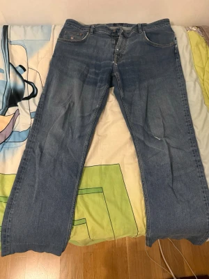 Blå raka jeans från GANT - Säljer ett par klassiska blå jeans från GANT med rak passform och fem fickor. Jeansen har en snygg tvättad look och är tillverkade i denim. Perfekta till en avslappnad stil och passar till det mesta.