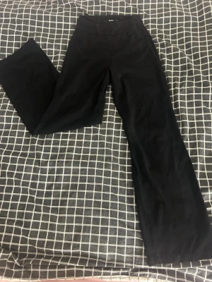 Svarta kostymbyxor Bik Bok 34 - Stilrena svarta kostymbyxor från Bik Bok i storlek 34. Byxorna har raka ben och hög midja, dragkedja vid sidan. Tyvärr lite korta för mig, är 170ish och de är ungefär 5cm för korta. Lite noppriga här och där men inget man ser eller märker av.