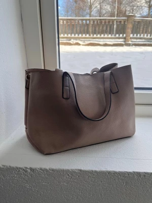 Handväska  - Rosa-beige färgad väska. Lite sliten inuti se bild. Snygg men inte riktigt min stil därav säljer jag! 