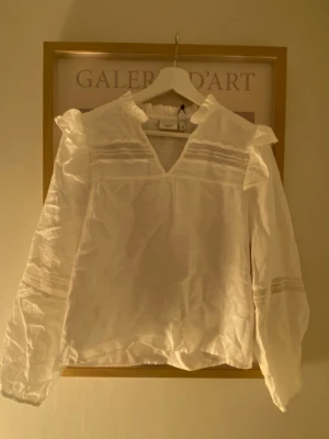 Åhlens blus - Vit super fin blus med volang och spets detaljer, aldrig använd helt ny endast testad, lappen kvar. 599 kr nypris därför priset