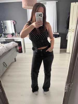 Svarta raka jeans med fickdetaljer - Säljer ett par svarta jeans med raka ben och klassiska fickor både fram och bak. Jeansen har en enkel design med knapp och dragkedja framtill. Perfekta till vardags och lätta att matcha med olika toppar. Var populära från lager 157 