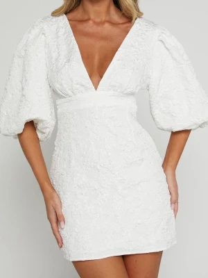 INTRESSEKOLL- VIT KLÄNNING SHOWPO - Superfin vit kort klänning med djup v-ringning och puffiga trekvartsärmar. Klänningen har en markerad midja och är gjord i ett strukturerat tyg som ger en lyxig känsla. Perfekt för student eller sommarens alla tillfällen. 