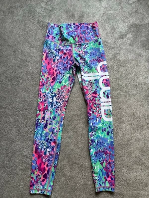 Flerfärgade tights från amin - Säljer ett par färgglada tights från amin. De har hög midja och ett mönster i blått, rosa, lila, grönt och vitt. 