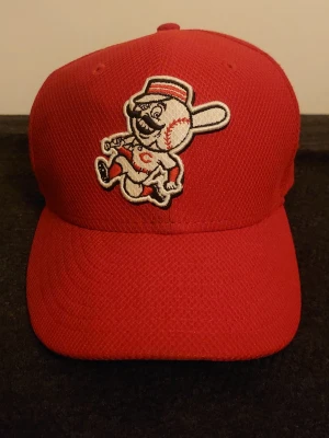Röd Cincinnati Reds keps MLB - Säljer en röd keps med broderad Cincinnati Reds-maskot framtill och MLB-logga bak. Klassisk böjd skärm och ventilerande mesh-liknande material. Perfekt för dig som gillar baseball eller vill ha en sportig accessoar. Pris går att sänkas 