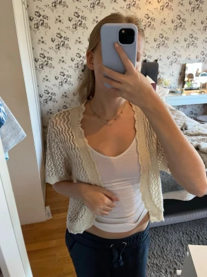 Beige virkad kofta - Kortärmad beige virkad kofta från Brittany Black. Koftan hae guldglitter i tyget så en super fin detalj. Passar mig bra som är XS/S i topp