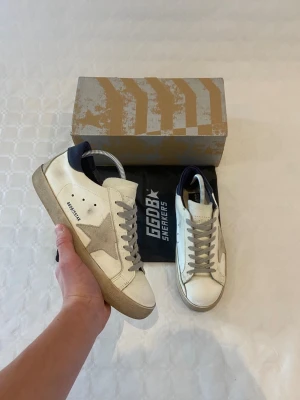 Golden goose skor - Säljer ett par riktigt feta golden goose skor i storlek 43. Man får med box och dustbag. Skorna är i fint skick. Har inget kvitto så kan inte garantera äktighet.  Skriv gärna vid funderingar 🤝🔥  priset är ej hugget i sten ✅👍👑