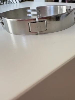 Stilrent Stainless steel  armband från Edblad - Snyggt armband i blankt silverfärgat metall från Edblad. Armbandet har en modern, länkad design med rektangulära länkar och små gnistrande stenar mellan länkarna som ger extra bling. Perfekt accessoar för dig som gillar stilrena och trendiga smycken.