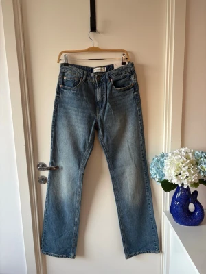 Stradivarius straight wide jeans - Snygga bla jeans från Stradivarius i modellen straight wide. Hög midja som sitter fint i midjan och raka, nagot vidare ben för en trendig och tidlös look. Perfekta vardagsjeans som enkelt kan stylas både casual och mer uppklätt. Klassisk blå tvätt som passar till allt. Storlek: 40 Modell: High waist, straight wide Skick: Mycket fint skick / nyskick Sökord: #jeans #stradivarius #straightjeans #wideleg #highwaist #bläjeans #denim #trend #basplagg #vardag #outfit #y2k #retro #90s #casual #streetsty
