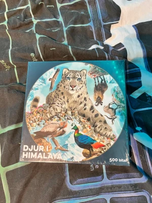 Pussel Djur i Himalaya 500 bitar - Ett färgglatt pussel med motiv av snöleopard och andra djur från Himalaya. Pusslet har 500 bitar och kommer i en fyrkantig kartong. Perfekt för dig som gillar natur och utmaningar. Text på svenska på kartongen.