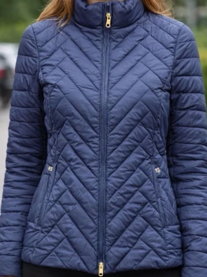 Mörkblå Gant quiltad pufferjacka - Snygg mörkblå Gant pufferjacka med quiltat mönster och guldfärgade detaljer på dragkedja och fickor. Jackan har hög krage, figurnära passform och långa ärmar. Perfekt för kyliga dagar och ger en trendig look.