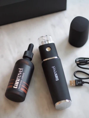 Tanrevel spraytan kit svart - Smidigt spraytan kit från Tanrevel i svart med silverdetaljer. Innehåller en elektrisk spraytan-apparat, två flaskor tanning liquid och USB-laddare. Perfekt för att få en jämn solbrun färg hemma. Modern design och enkel att använda.