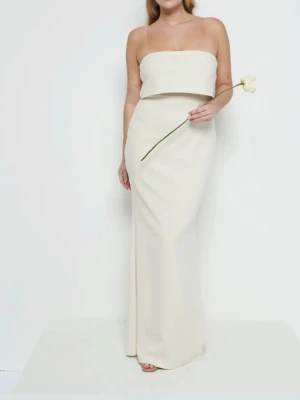 Vit axelbandslös långklänning - Trendig vit långklänning med axelbandslös design och rak, figurnära passform. Klänningen har en enkel och stilren look med ett dubbelt lager över bysten för en modern touch. Perfekt för sommarens alla tillfällen.