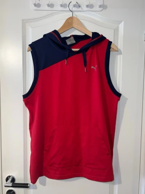 Röd ärmlös hoodie från Puma - Röd ärmlös träningströja/hoodie från Puma i storlek S. Helt ny och oanvänd. Lätt och bekvämt material, perfekt för träning eller en sportig vardagsstil. Finns att hämta i Södertälje eller Örebro.