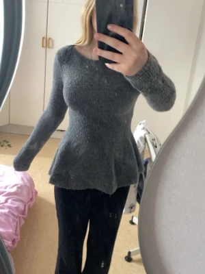 Grå peplumstickad tröja - Mysig grå stickad tröja från H&M, stället Xs, säljer då den inte kommit till någon användning, använd ca 1 gång. Super snygg till ett par snygga jeans, köpte för 250 kronor säljer för 100 kronor men pris går att diskutera, hör av er vid frågor🥰