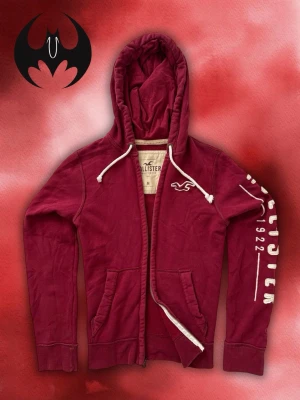 Vintage Hollister Hoodie-Zip - Säljer denna sällsynta rödvin Hollister zip hoodie | Mycket bra skick | size M | Längd: 70cm Bröstvidd: 54cm Armlängd: 73cm | Skyltdocka: M - 48 cm axlar, 75 cm midja| Lägg endast bud med avsikt att köpa nu, inga fördröjning! Pris är inte hugget i sten!