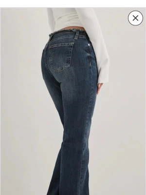 Mörkblå bootcut jeans med låg midja - Säljer ett par mörkblå bootcut jeans med låg midja och klassiska fickor bak. Såå fina jeans men för korta för mig så aldrig använda!! Ny pris 600 kr