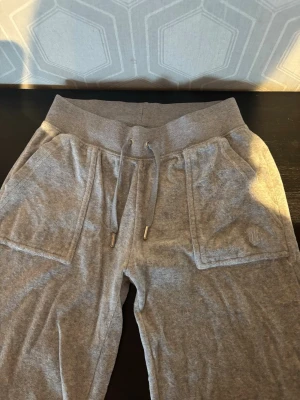 Grå mjukisbyxor Juicy - Säljer ett par gråa Juicy mjukisbyxor. Byxorna har stora fickor fram och raka ben. Perfekta för chill dagar hemma eller när du vill vara bekväm. 