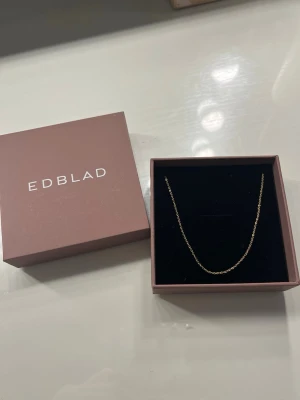 Guldhalsband från Edblad 49cm  - ( priset går att diskutera vid snabb affär )Snyggt och stilrent halsband i guldton från Edblad. Kedjan är tunn och elegant med en enkel design som passar till många olika looks. Levereras i original ask från Edblad. Perfekt accessoar för dig som gillar minimalistisk stil.
