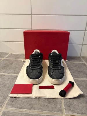 Valentino Flycrews! Glittriga sneakers svart/vit - Snygga sneakers från Valentino med svart glitter och vita detaljer. Storlek 37,5. Skick 8/10, en nit saknas i övrigt så gott som nya. Medföljer box, dustbag, Valentino-kort & nya skosnören. Köpta tidigare här på Plick.  