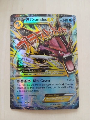 Pokémonkort Mega Gyarados EX - Säljer ett samlarkort från Pokémon, Mega Gyarados EX med holografisk yta. Kortet har färger i blått, gult och rött med japansk text och coolt motiv av Gyarados. Perfekt för dig som gillar Pokémon eller samlar på kort.