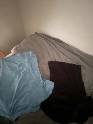 SOC svart t-shirt och blå t-shirt - Två t-shirts, en svart från SOC och en ljusblå. Båda har klassisk rund hals och korta ärmar. Perfekta för dig som gillar enkel och sportig stil. Materialet är troligtvis polyester , vilket gör dem bekväma och lätta att bära.