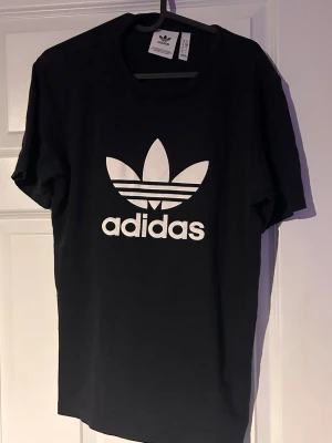 Svart Adidas t-shirt med logga - Svart t-shirt från Adidas med Adidas-tryck på bröstet. (Har litet märke) 