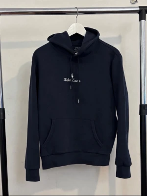 Blå hoodie från Ralph Lauren - Snygg blå hoodie från Ralph Lauren med vit broderad logga på bröstet. Den har inga defekter och är i mycket bra skick i storlek s.