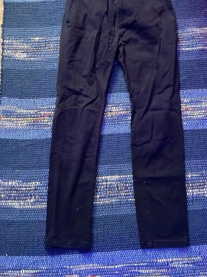 Mörkblå raka jeans - Säljer ett par märkblåa jeans med rak passform och klassisk femficksdesign. Jeansen har normal midja och är tillverkade i ett mjukt denimtyg. Perfekta för dig som gillar en enkel och stilren look.